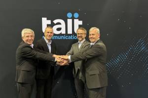 Four business men from Frequentis and Tait shaking hands