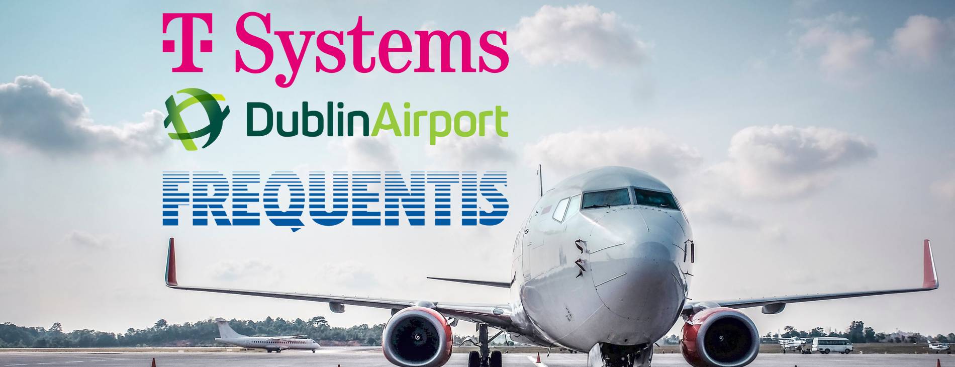 ein stehendes Flugzeug; im Himmel sind die logos von T Systems, Dublin Airport, and Frequentis zu sehen