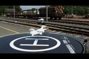 Drone leaving drone hangar beside rail tracks