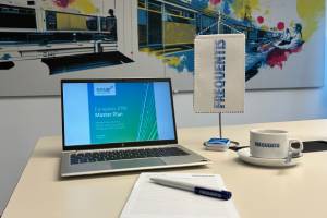 Schreibtisch mit: Computerbildschirm zeigt den SESAR European ATM Master Plan, Kaffeetasse, Schreibblock, Kugelschreiber