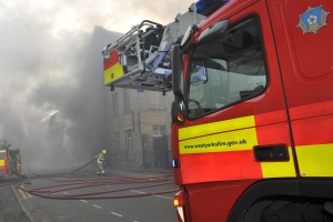 ein Feuerwehrauto vor einem brennenden Haus