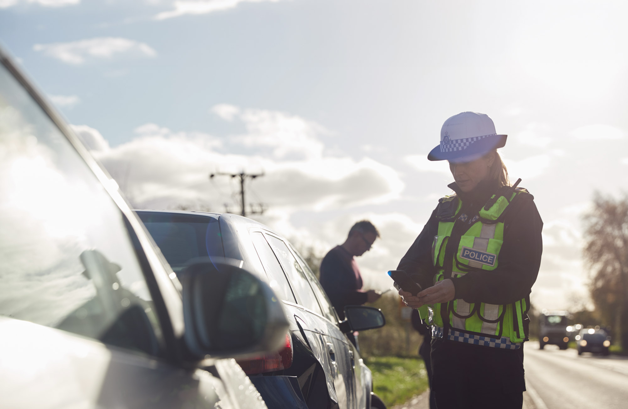 Mission Critical Services in control rooms header picture, showing a police officer, another person, and cars