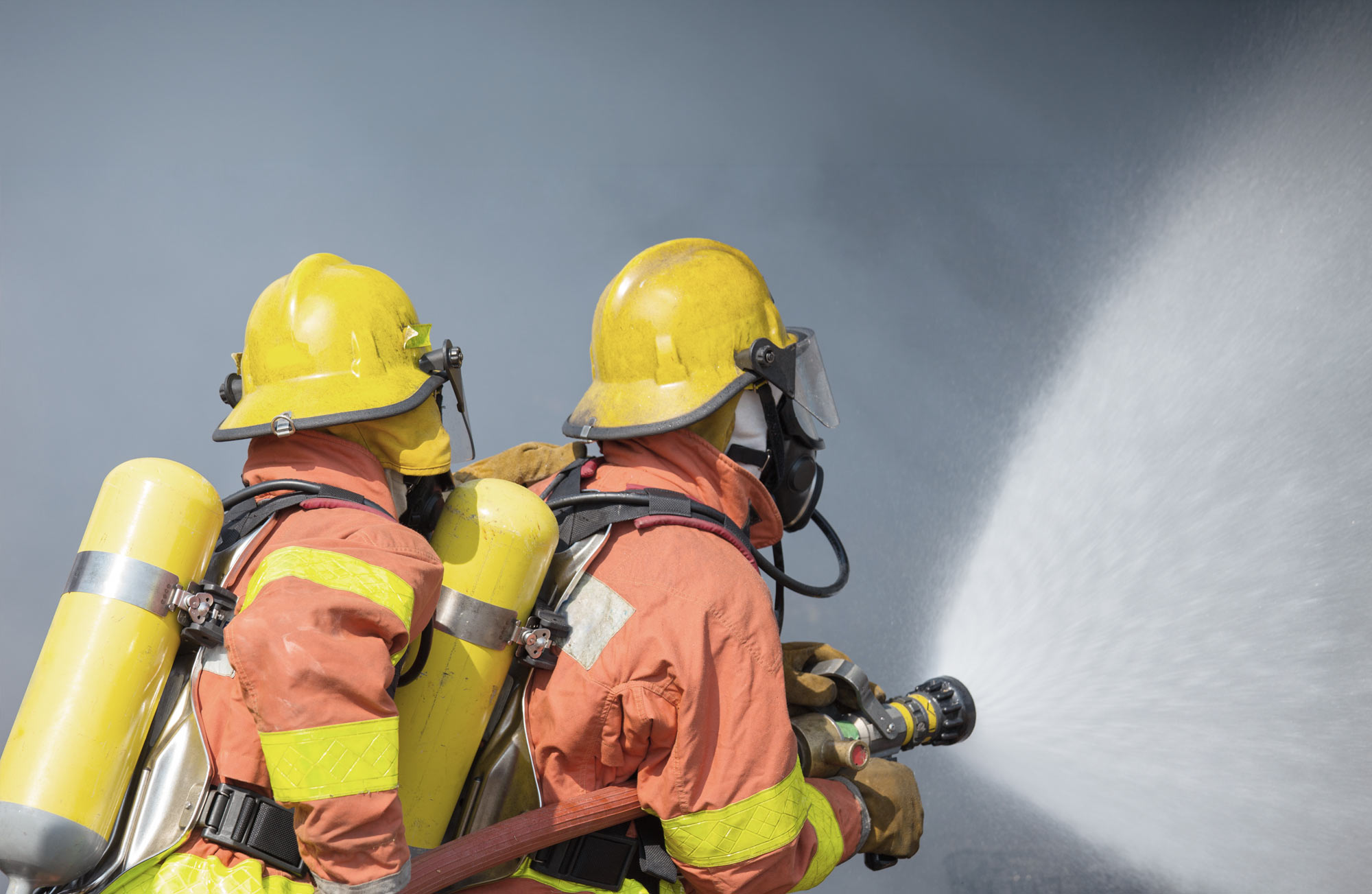 header image fire services, showing two fire fighters in action