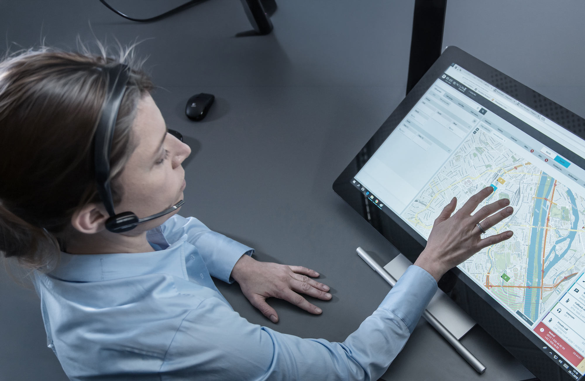 Connectivity Suite header picture, showing a female operator, using a touch screen