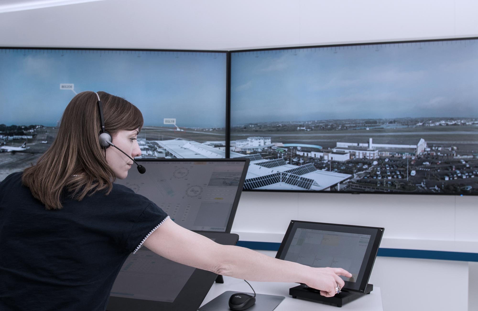 Remote digital tower header picture, showing a woman operating and several screens