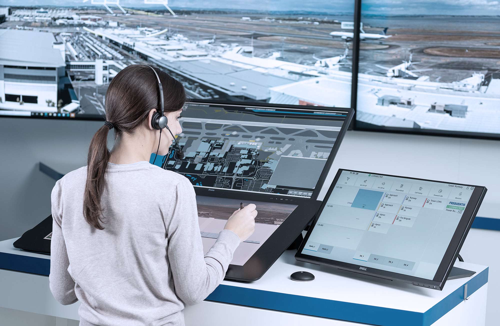 Tower Products header picture, showing a woman operating and several screens