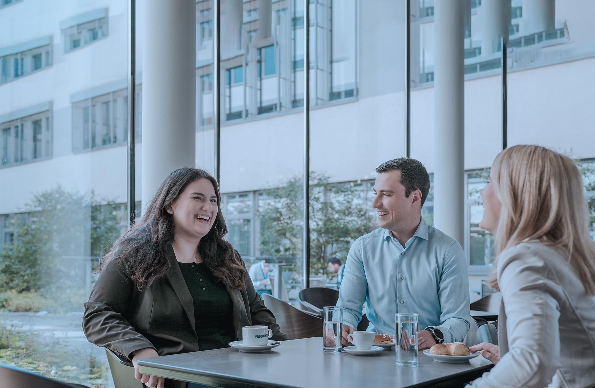 Working at Frequentis in Germany header picture, showing 3 colleagues at a coffee break