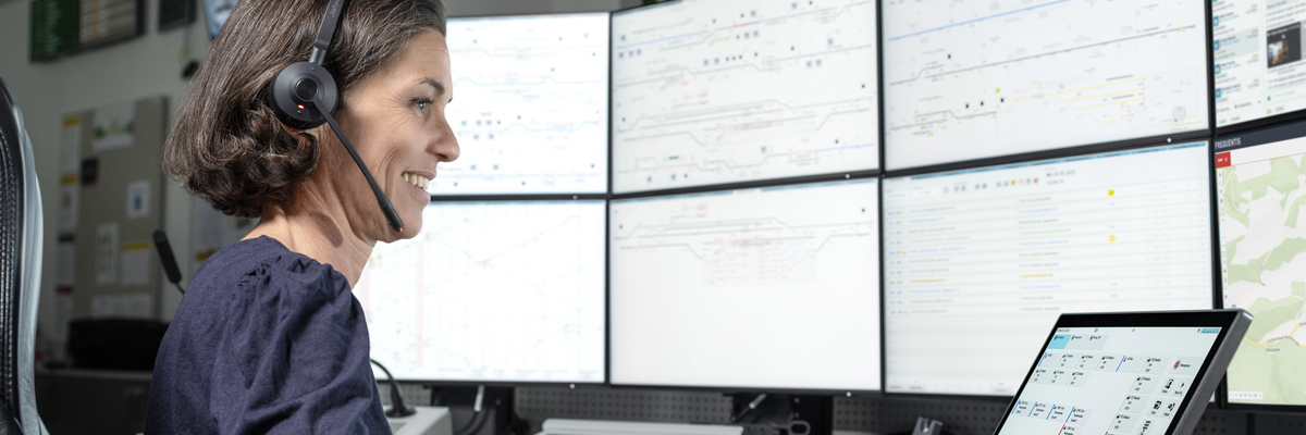 rail management, picture showing a person operating in front of the control room screens