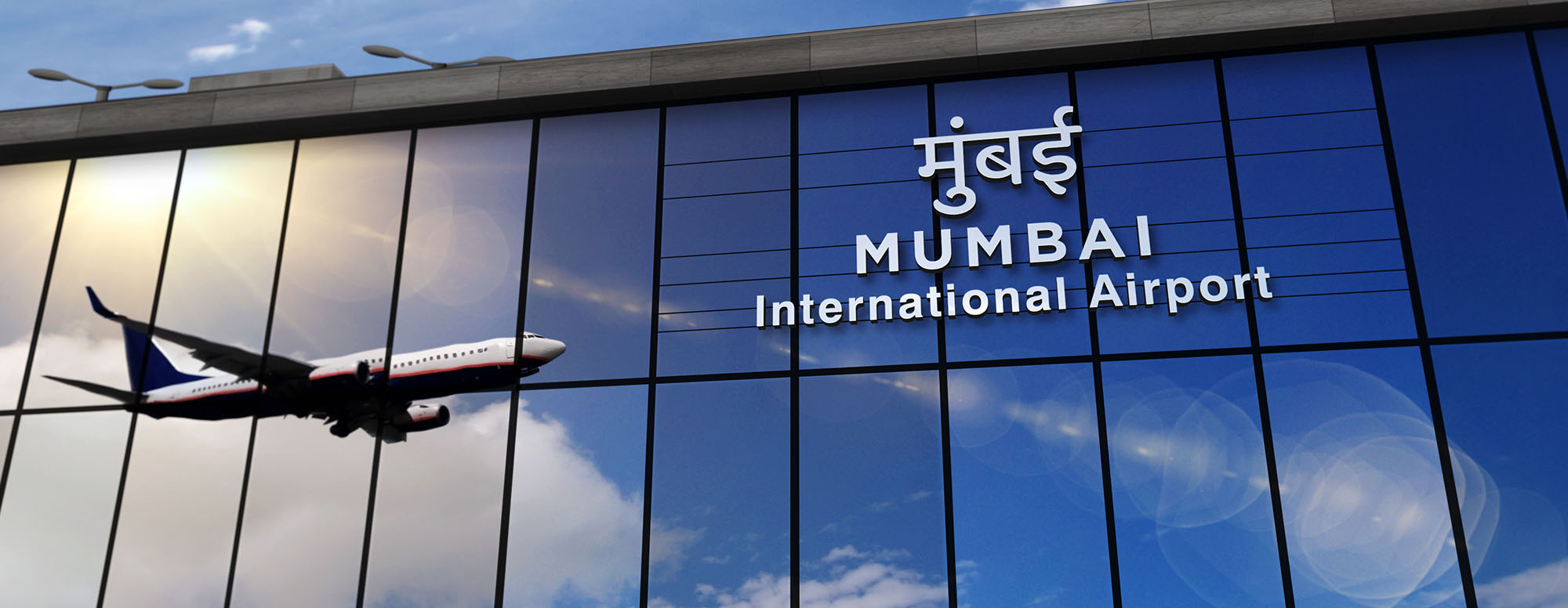 ein Flugzeug spiegelt sich in der Glasfassade des Mumbai International Airports