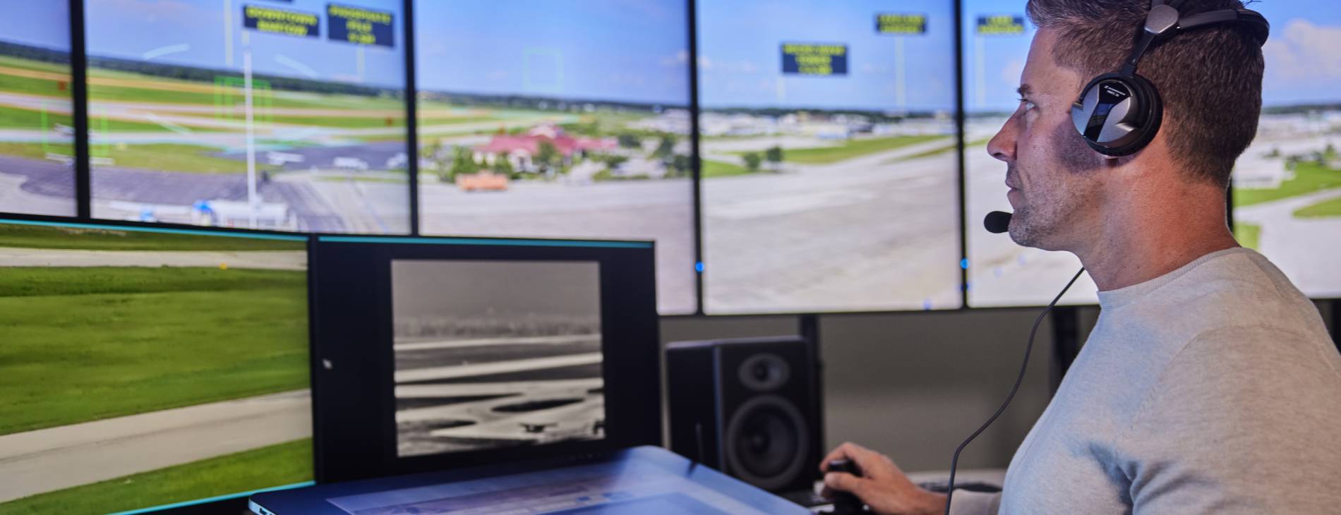 a male air traffic controller infront of screens of a digital tower